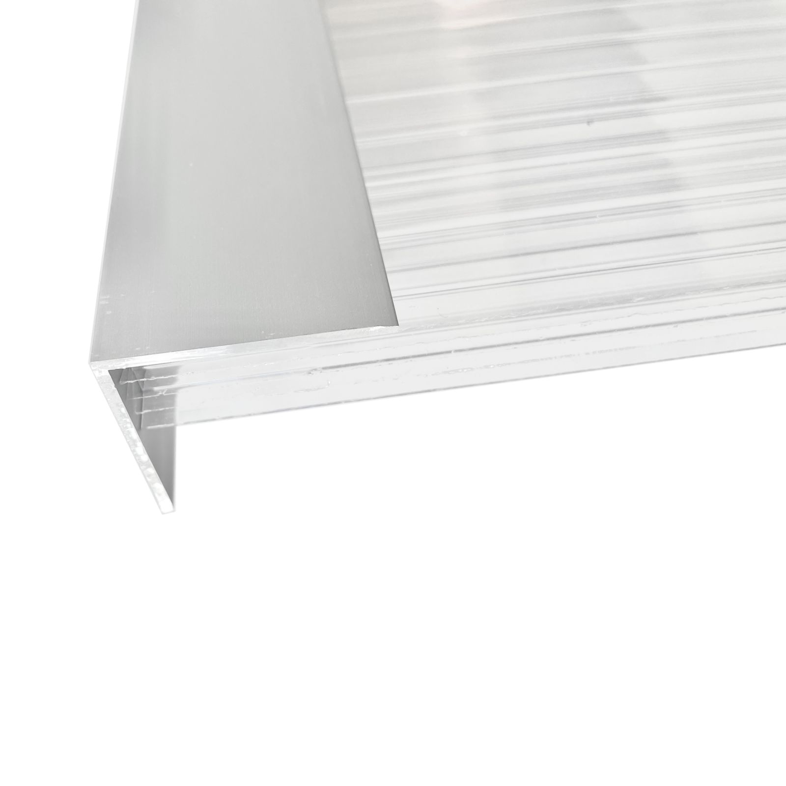 Toiselta puolelta nähty alumiininen L-profiili, kiinnitetty kennopolykarbonaattilevyyn